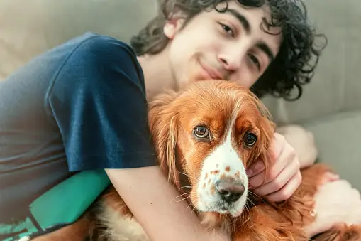 A boy hugging a dog